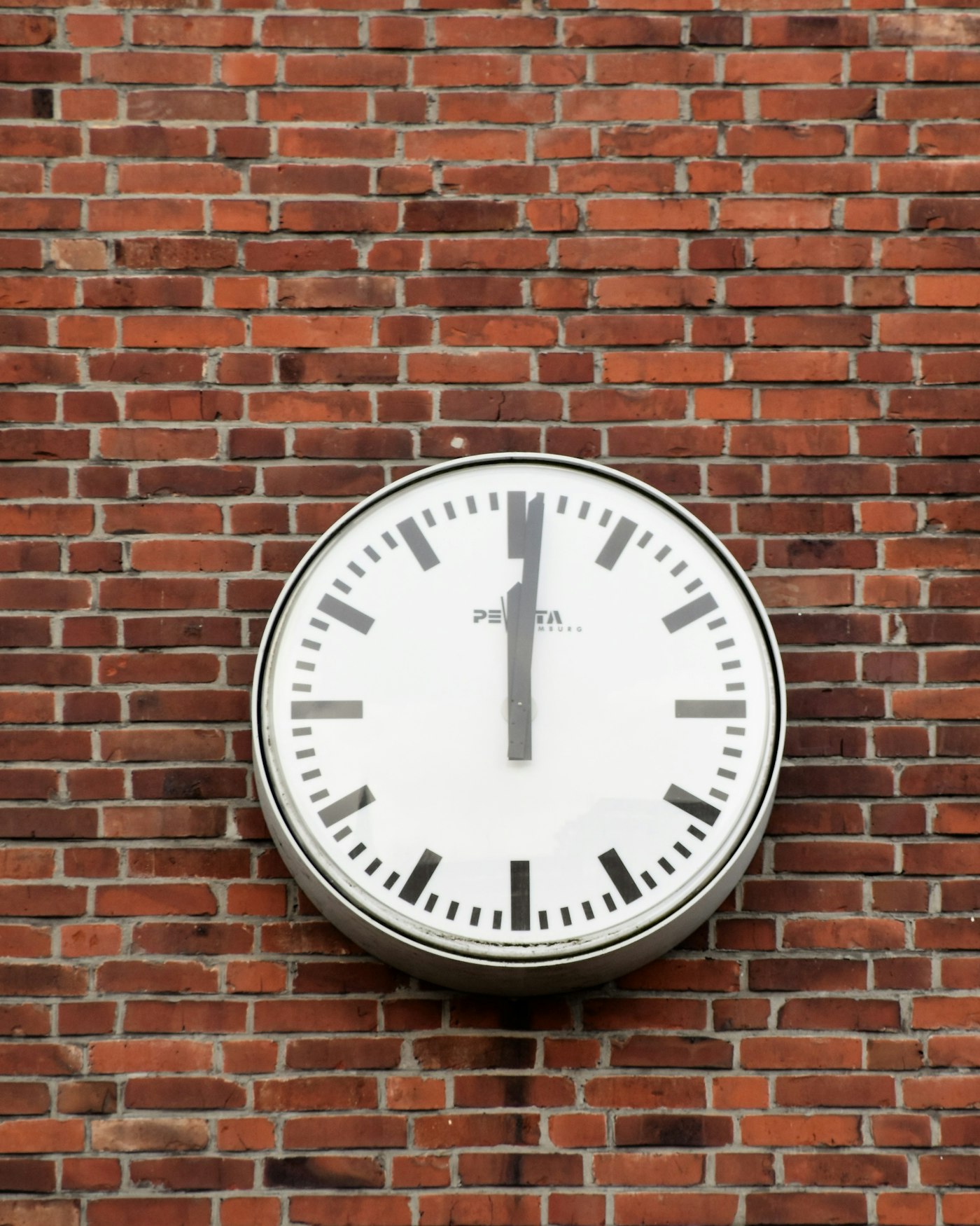 Reloj industrial de pared sobre un muro de ladrillo