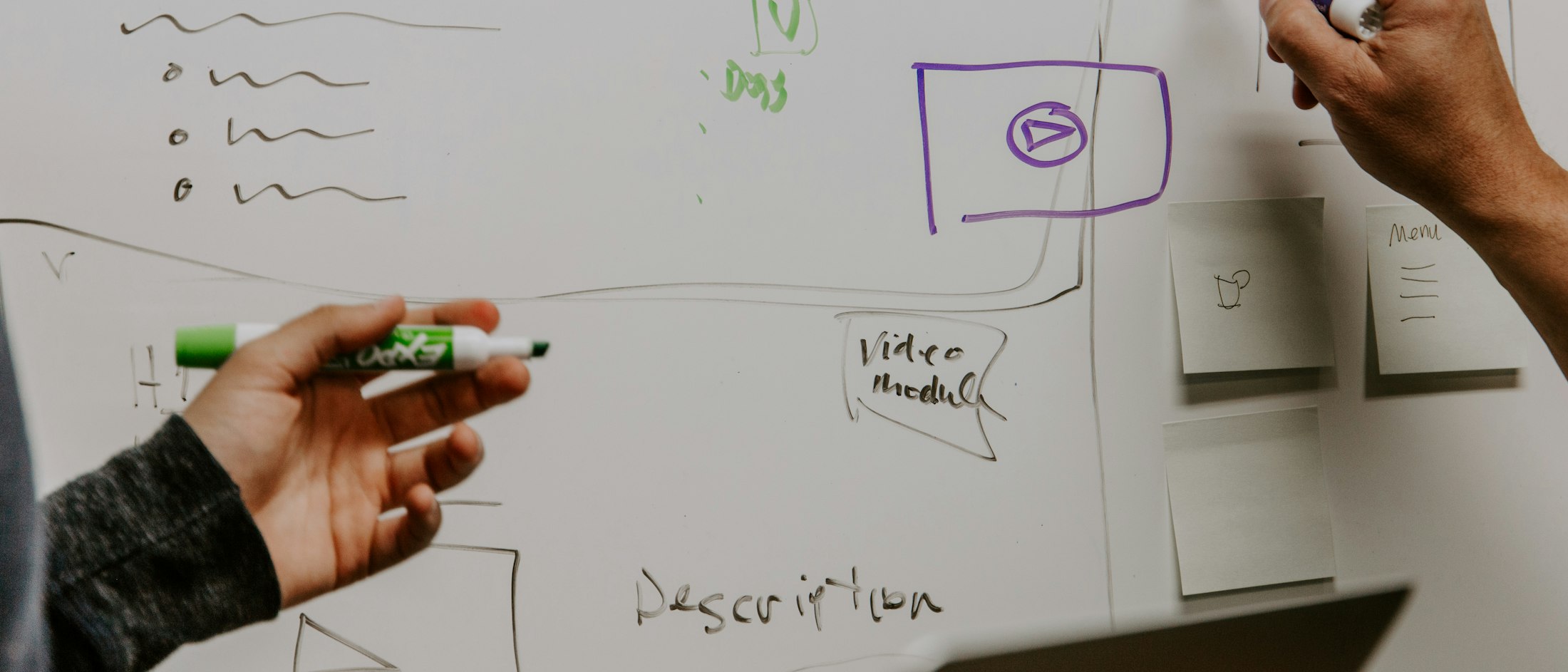Dos personas dibujando un diagrama a mano sobre una pizarra blanca